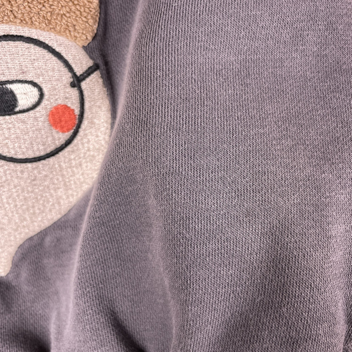 Kleiner Fleck vorne rechts neben dem Motiv am Minories Baby-Sweatshirt