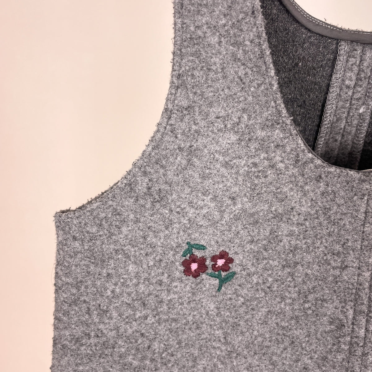 Nahaufnahme der kleinen bordeauxfarbenen Blumenstickerei am Zara Kleid